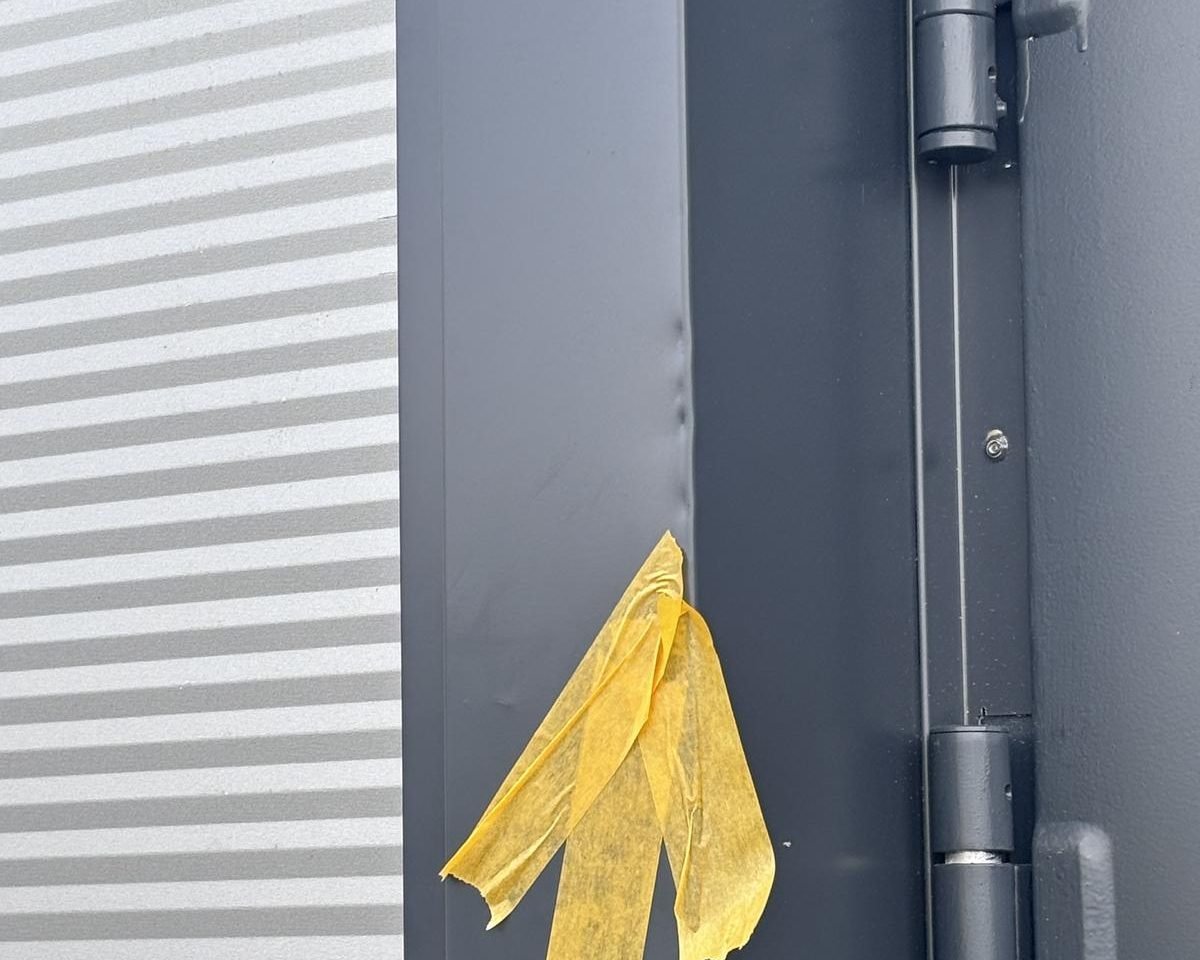 Nahaufnahme der Faltkante des Laibungsblechs vor der Reparatur, mit Markierung — der Verzug der Kante ist auf dem Foto kaum zu erkennen.